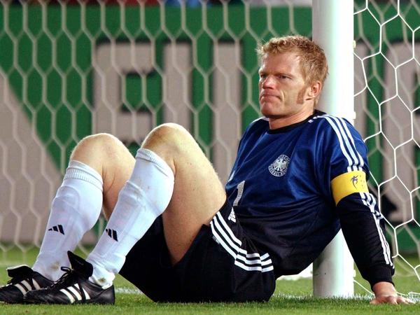 Der deutsche Torhüter und Kapitän Oliver Kahn sitzt nach der Niederlage gegen Brasilien bei der WM 2002 deprimiert am Pfosten.