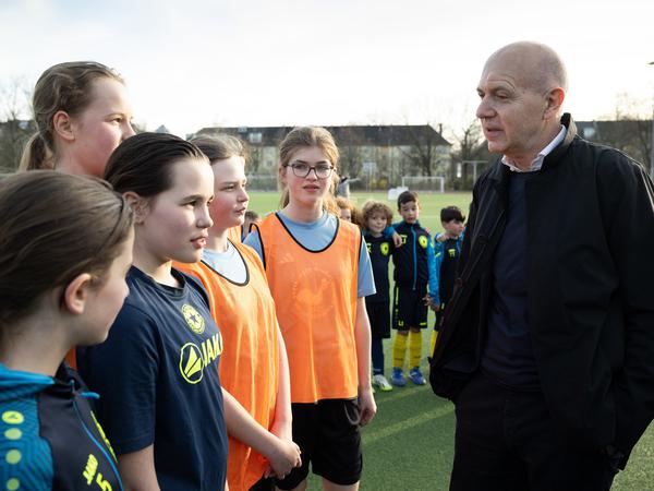 DFB-Präsident Bernd Neuendorf unterhält sich mit Kindern vom FC Stern 1900.