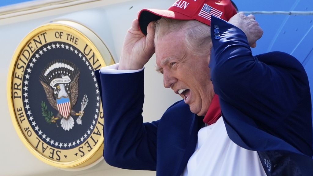 Donald Trump vom Winde verweht: Beim Verlassen der "Air Force One" hat der US-Präsident seine liebe Not mit seiner Kopfbedeckung. (Foto)