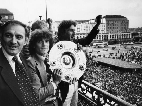 ARCHIV - 08.06.1979, NA, Hamburg: ARCHIV - Neben dem jugoslawische Trainer Branco Zebec (l) und Abwehrspieler Manfred Kaltz (r) zeigt der englische Stürmerstar Kevin Keegan (M) vom Hamburger SV am 09.06.1979 die Meisterschale. Am 14.02.2016 wird der ehemalige HSV-Spieler Keegan 65 Jahre alt. Foto\ Werner Baum/dpa +++(c) dpa - Bildfunk+++. Keegan starb im Alter von 75. Jahren. (zu dpa: «Englands Fußball-Legende Kevin Keegan stirbt im Alter von 75») Foto: Werner Baum/dpa +++ dpa-Bildfunk +++
