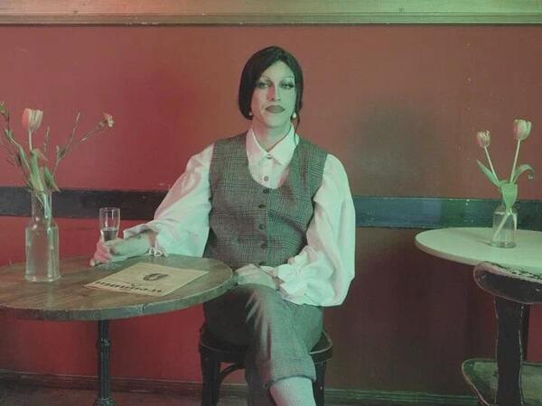 Videostill aus „The Continuation (DIE FREUNDIN)“ featuring die Drag-Künstlerin Hassandra in „Time Machine Infinitum. Queeres migrantisches Berlin“, 2026