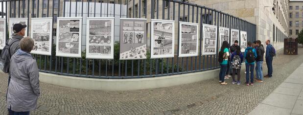 Es ist einer der wohl meistgelesenen Comics des Landes: Seit rund fünf Jahren hängt am Zaun des Bundesfinanzministeriums in der Niederkirchnerstraße die auf wetterfesten Postern gedruckte Bildgeschichte „Mit der Seilbahn über die Mauer“ von Thomas Henseler und Susanne Buddenberg. Darin erzählt das Berliner Zeichner-Autoren- Duo von der spektakulären Flucht der Familie Holzapfel 1965 in den Westen. Fast rund um die Uhr bleiben Touristen und immer wieder auch Berliner stehen und vertiefen sich in die Geschichte aus jener Zeit, als hier die deutsch-deutsche Grenze verlief. Foto: Lars v. Törne