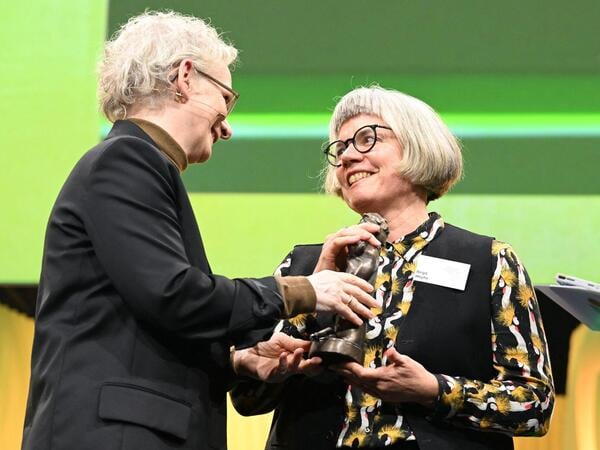 09.10.2026, Hessen, Frankfurt/M.: Petra Bahr (l), Staatssekretärin im Bundesministerium für Familie, Senioren, Frauen und Jugend, übergibt Autorin Birgit Weyhe den goldenen Momo in der Kategorie Sachbuch mit ihrer Graphic Novel «Schweigen» beim Deutschen Jugendliteraturpreis 2026 auf der Frankfurter Buchmesse. Die 78. Frankfurter Buchmesse findet vom 7. - 11. Oktober 2026 statt. Foto: Jennifer Brückner/dpa +++ dpa-Bildfunk +++